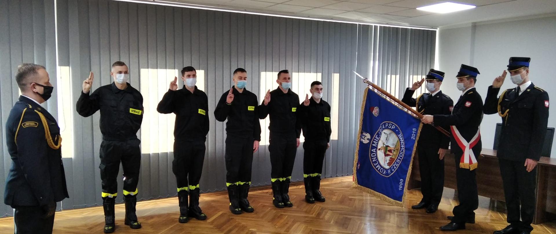 Na zdjęciu pięciu nowoprzyjętych stażystów w umundurowaniu koszarowym składających ślubowanie, poczet sztandarowy Komendy Miejskiej Państwowej Straży Pożarnej w Częstochowie oraz dowódca uroczystości.