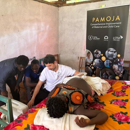 Lekarz wykonuje badanie usg przez brzuch ciężarnej kobiety, dwóch innych mężczyzn obserwuje monitor