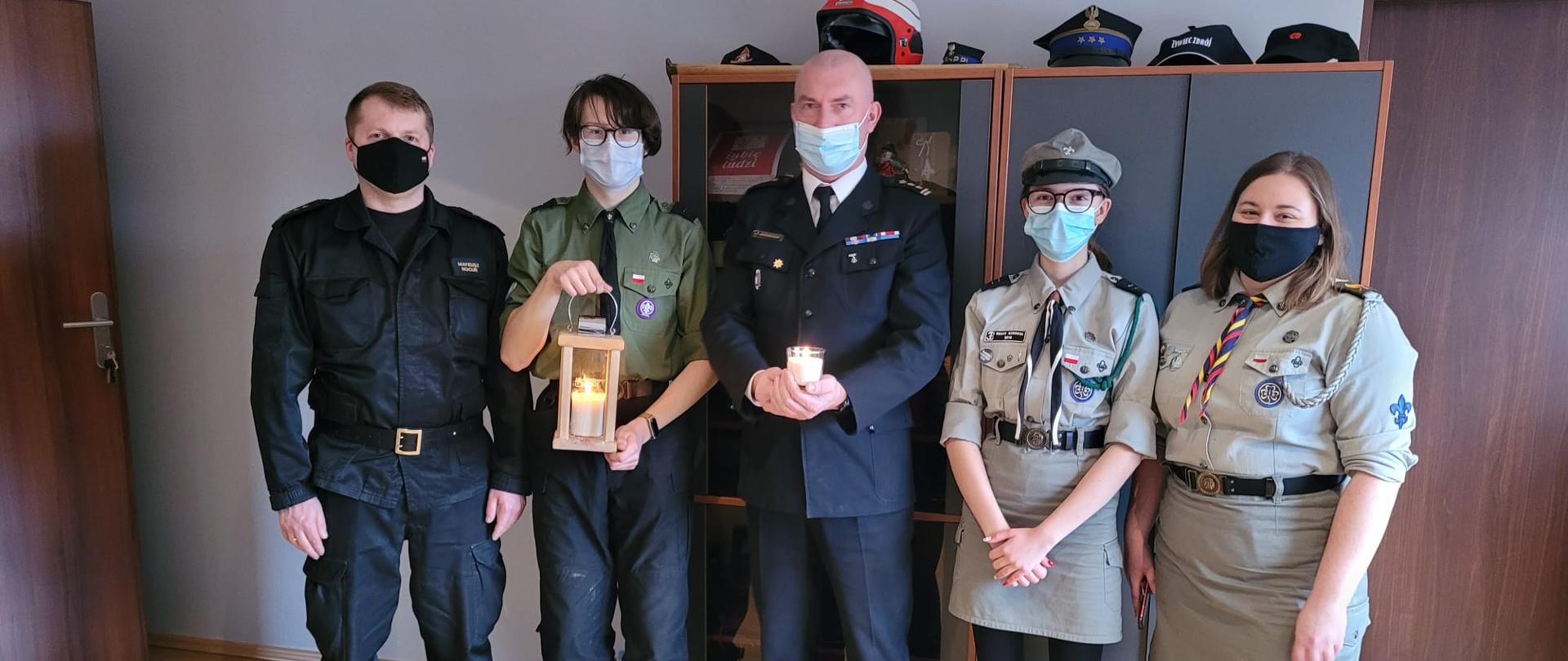 Zdjęcie przedstawia kierownictwo KP PSP w Myszkowie oraz harcerzy wręczających światełko Betlejemskie