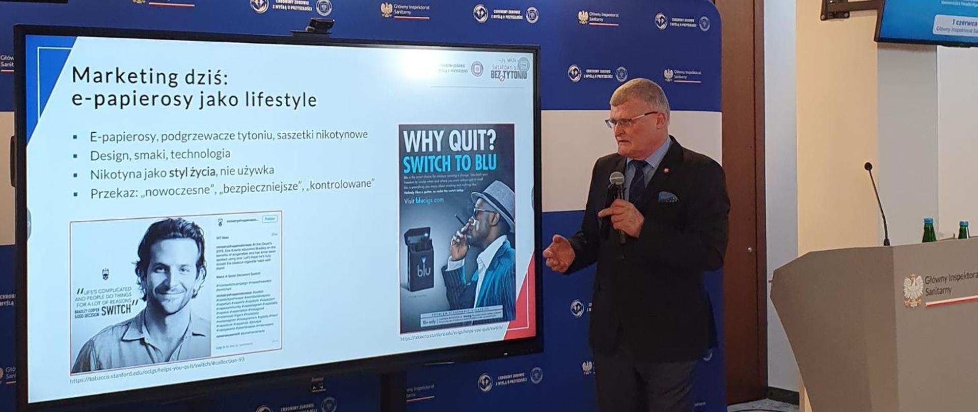 mężczyzna stojący przed ekranem prezentuje wykład