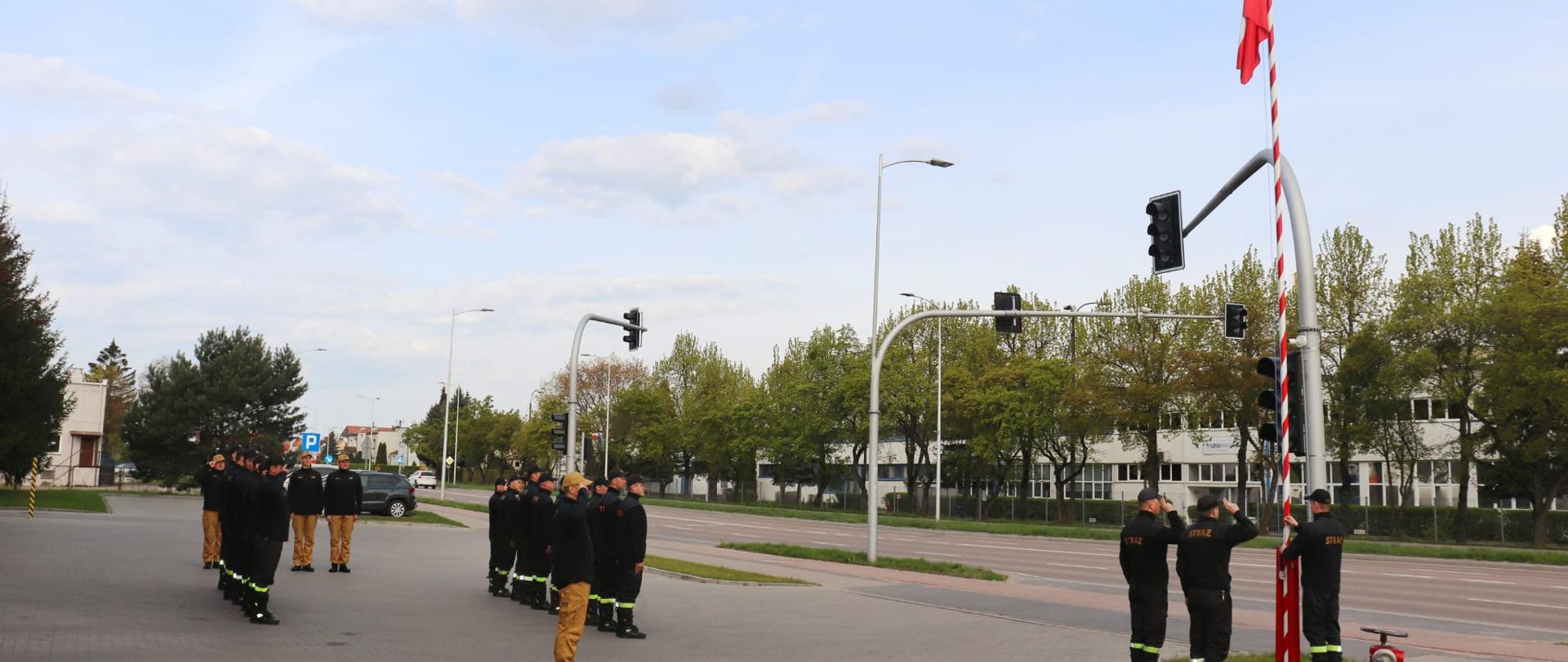 Strażacy zgrupowani podczas uroczystego podniesienia Flagi Państwowej 