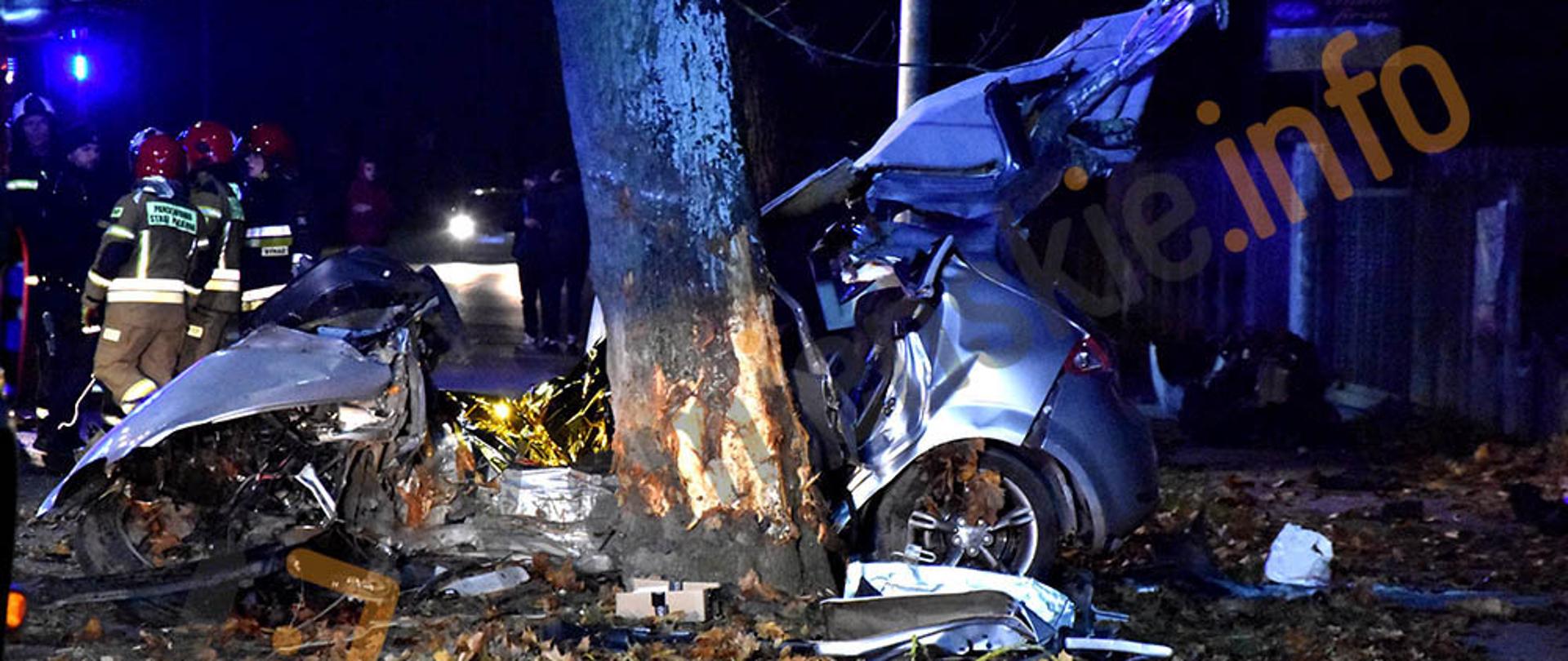 Na zdjęciu widać rozbite auto oraz strażaków