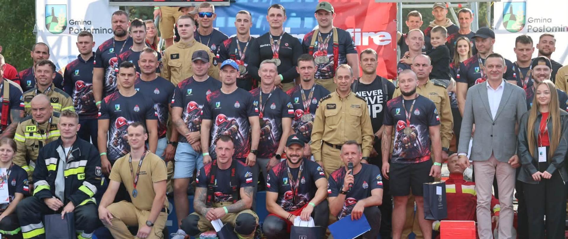 Uczestnicy, obsługa techniczna toru, przedstawiciele lokalnych samorządów oraz funkcjonariusze PSP podczas wspólnego zdjęcia po zakończeniu zawodów.