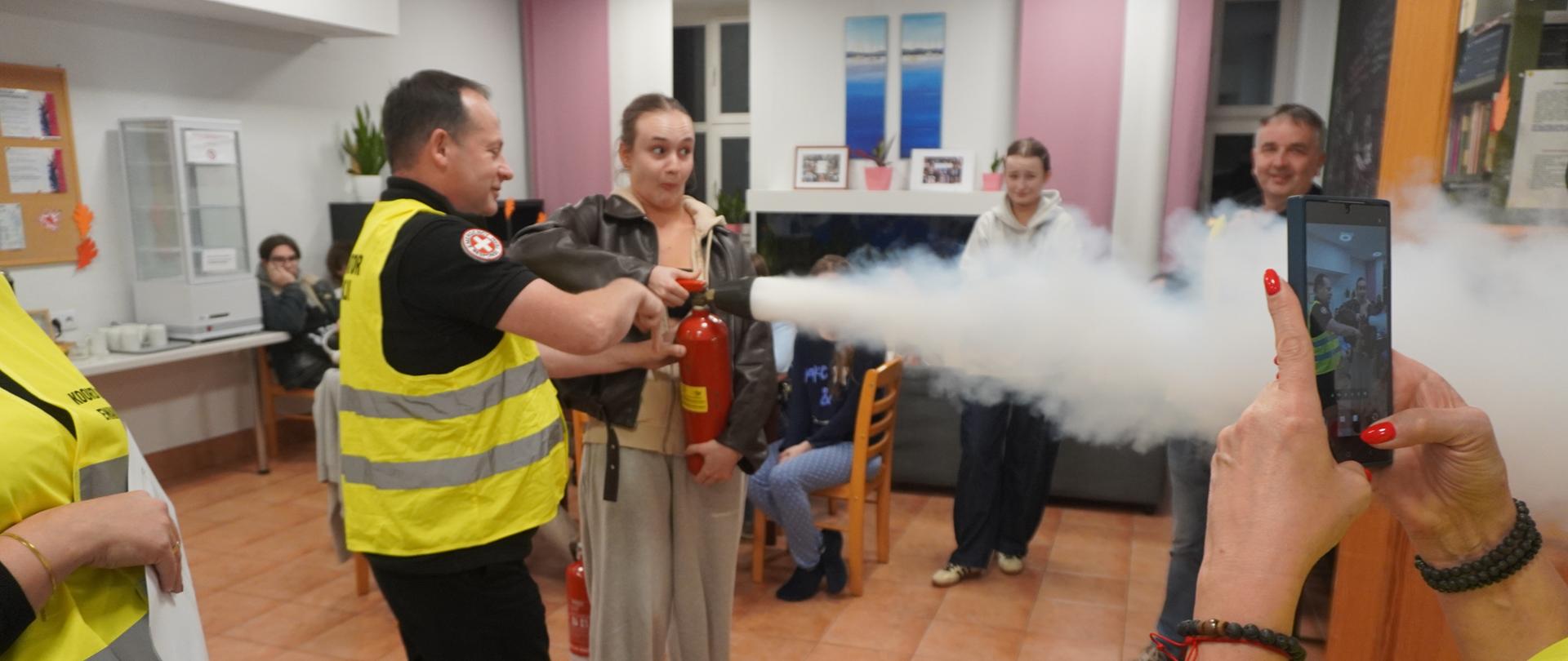 Wychowanka używa gaśnicy.