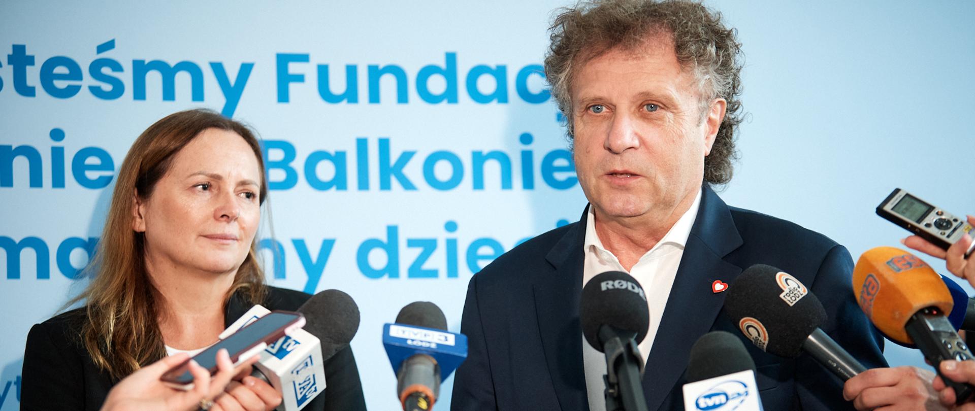 Wiceminister Jacek Karnowski oraz marszałek Joanna Skrzydlewska podczas briefingu stoją przed mikrofonami