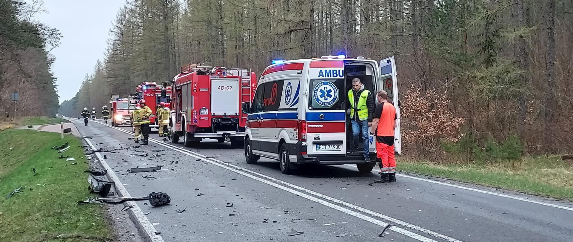 Kolumna pojazdów ratowniczych, resztki pokolizyjne na jezdni.