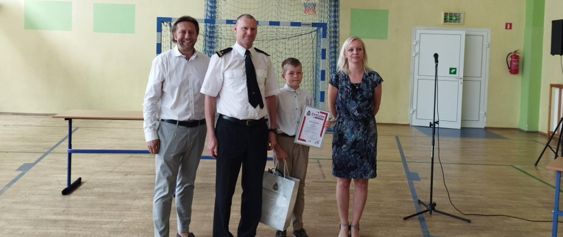 na zdjęciu widoczny nagrodzony zastępca komendanta powiatowego i dyrekcja szkoły