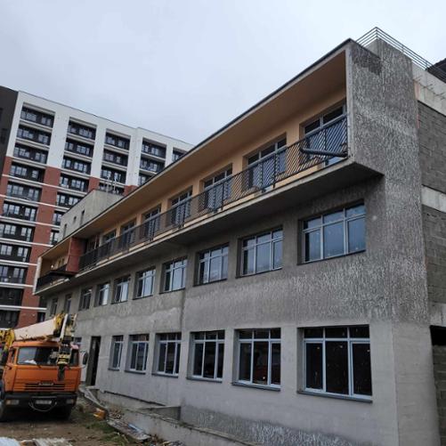 W sąsiedztwie nowego bloku mieszkalnego stoi dwupiętrowy budynek centrum znajdujący się na etapie prac wykończeniowych