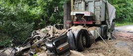 Zdjęcie przedstawia zniszczony samochód ciężarowy po zderzeniu z drzewem. 