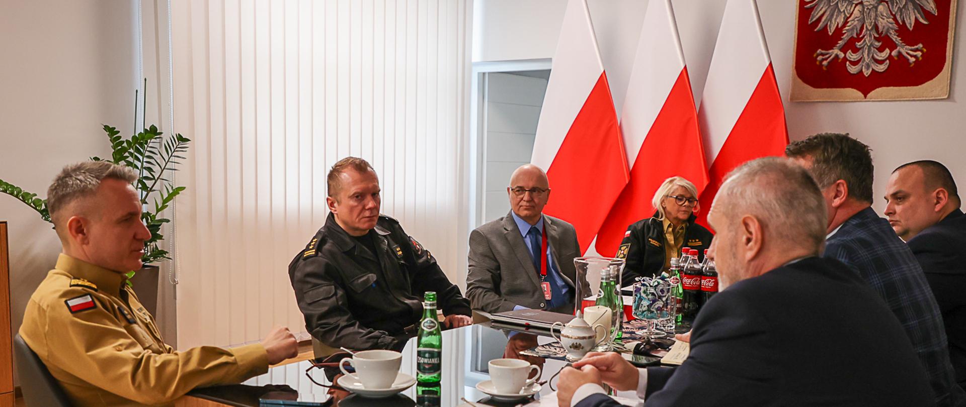 Komendant Główny PSP wraz z kadrą KG PSP oraz przedstawicielami związków zawodowych siedzą przy stole podczas rozmów