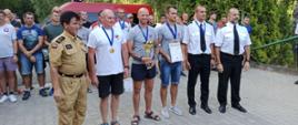 Na zdjęciu Zastępca Podkarpackiego Komendanta Wojewódzkiego st. bryg. Andrzej Marczenia, Zastępca Komendanta Miejskiego w Przemyślu st. kpt. Ireneusz Dryniak, Zastępca Komendanta Miejskiego w Rzeszowie st. bryg. Krzysztof Filip oraz zwycięska drużyna z Przemyśla w składzie: Tomasz Śpiewak, Bartłomiej Klepacki, Kamil Piejko, w tle inni zawodnicy zawodów