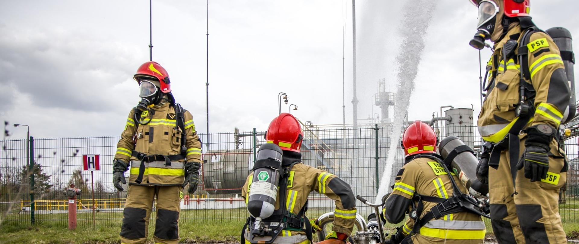 Ćwiczenia ratownicze "Synteza 2022" na terenie Zakładu Dużego Ryzyka powstania poważnej awarii przemysłowej w Kędzierzynie-Koźlu. Na zdjęciu strażacy podają prąd gaśniczy w kierunku zbiornika magazynowego niebezpiecznej substancji. 