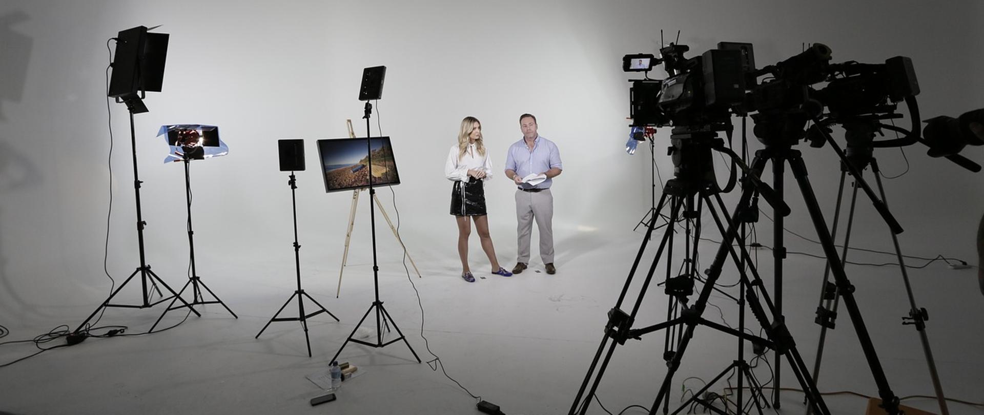 Zdjęcie przedstawiające dwóch prelegentów przez kamerami