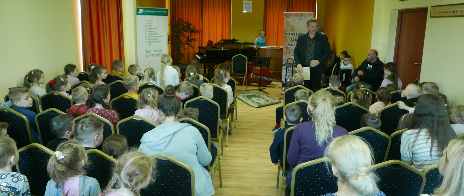 Wypełniona przedszkolakami aula szkoły, którzy przyszli na koncert oraz by poznać instrumenty muzyczne na których by chcieli w przyszłości grac.