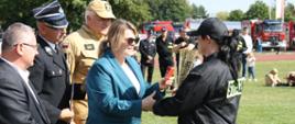 Strażaczka przyjmująca puchar od organizatorów zawodów OSP