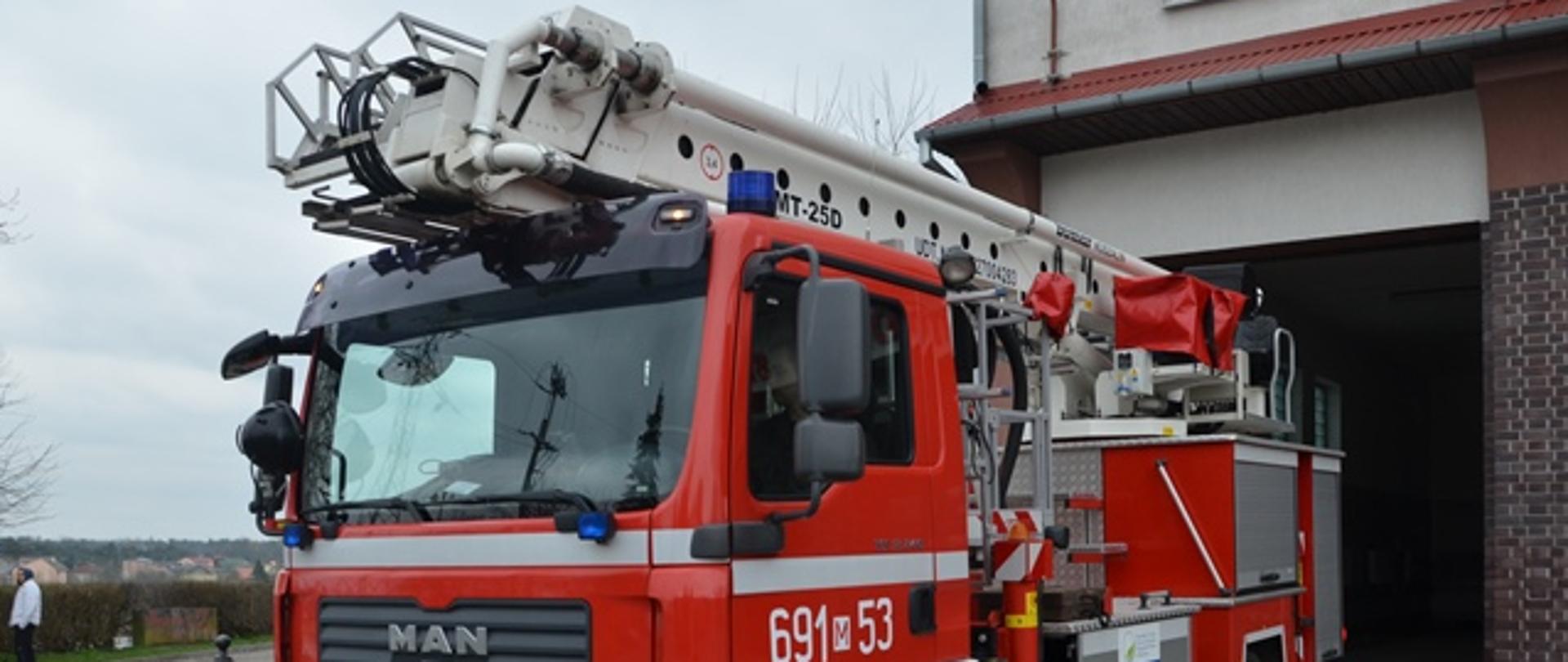 Pojazd strażacki na tle Komendy Powiatowej PSP