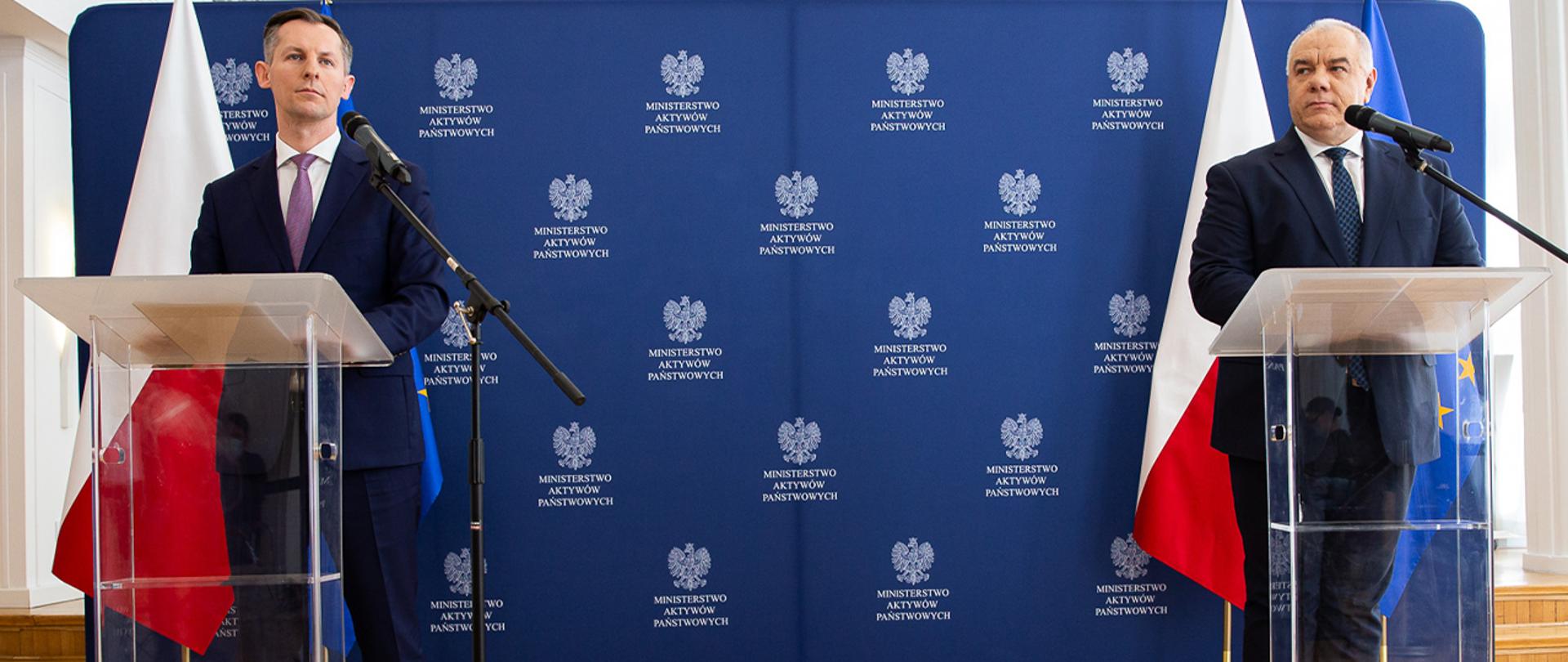 Szeroki plan sali konferencyjnej. Przy mównicach stoją szef MAP i szef UOKiKu.