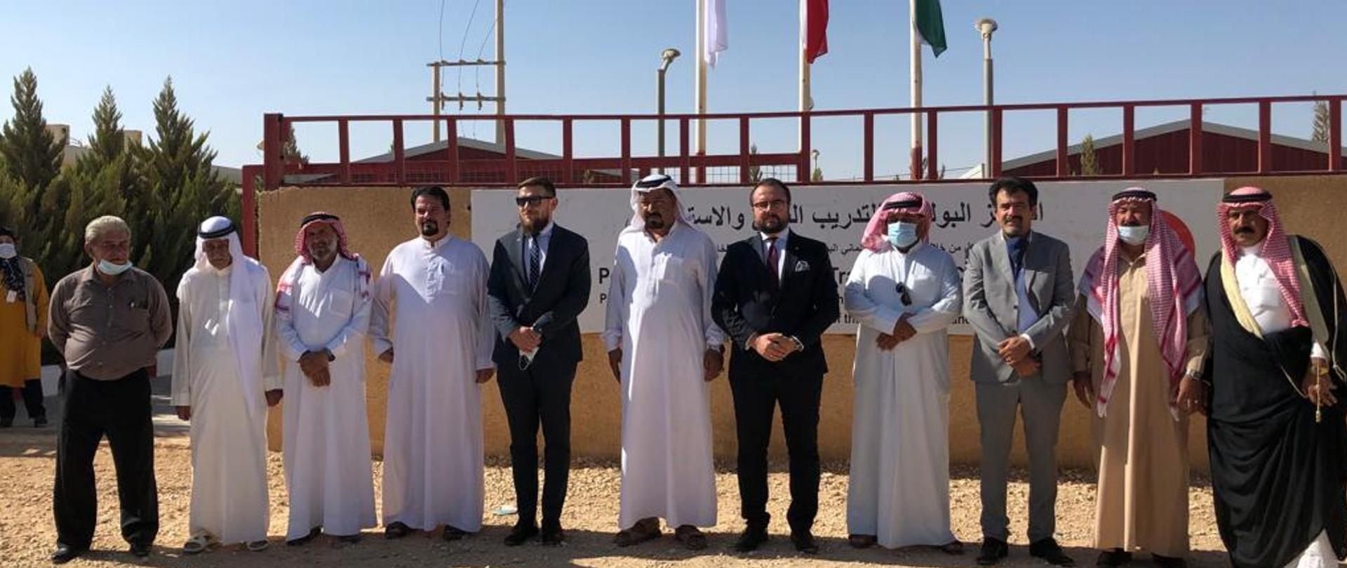 Mężczyźni ustawieni w rzędzie przed budynkiem