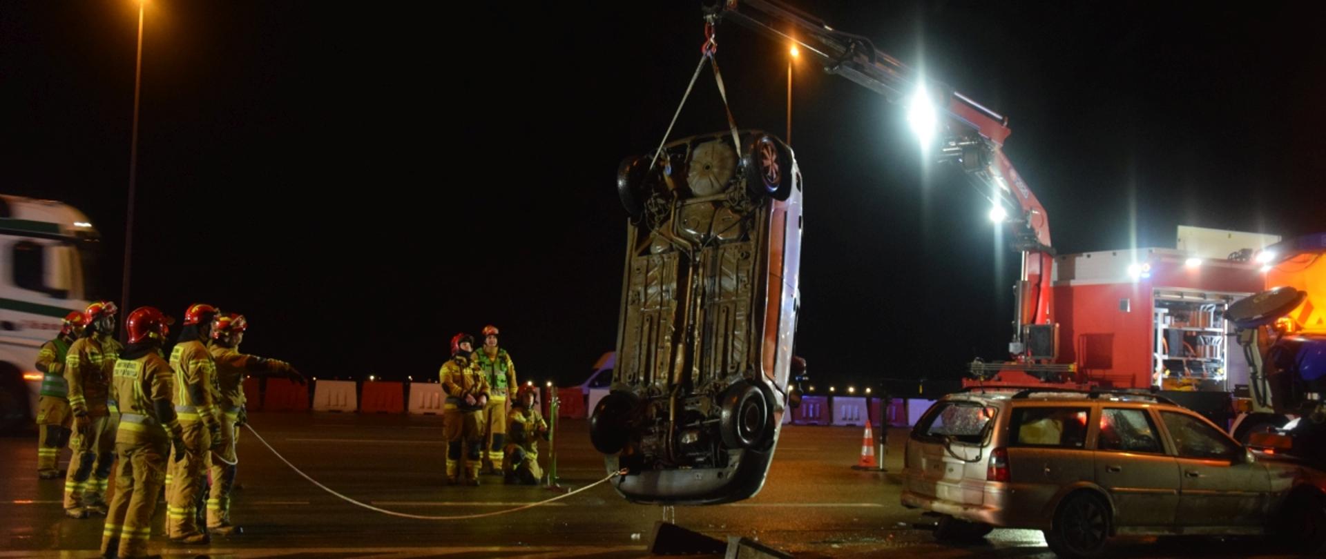 strażacy podczas podnoszenia samochodu osobowego