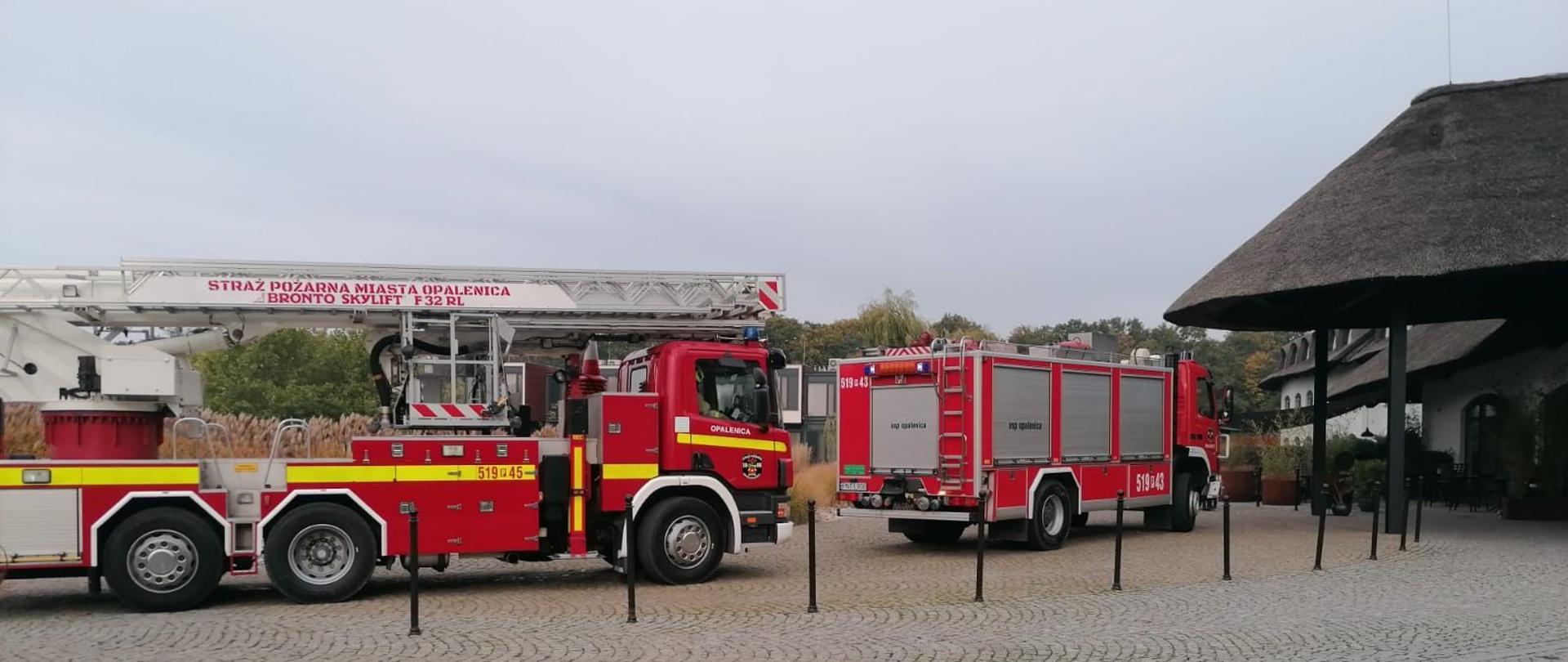 Dzień. Wozy strażackie przed wejściem głównym do hotelu.