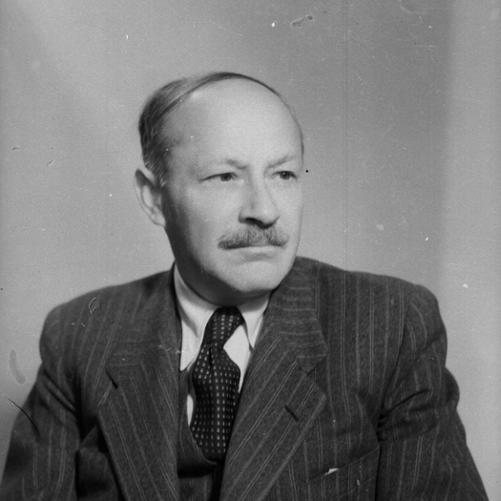 Zygmunt Modzelewski - portret mężczyzny z wąsem, ciemne włosy, ciemna marynarka w paski, ciemny krawat w drobne wzorki, biała koszula.