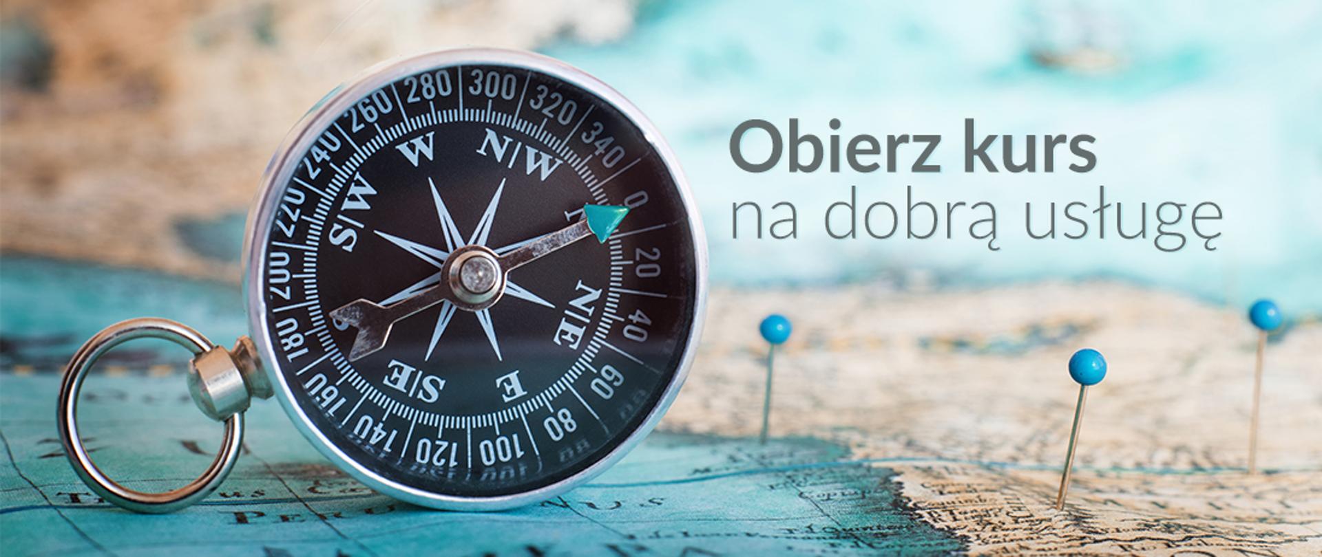Baner z napisem "Obierz kurs na dobą usługę". Na banerze mapa i kompas.