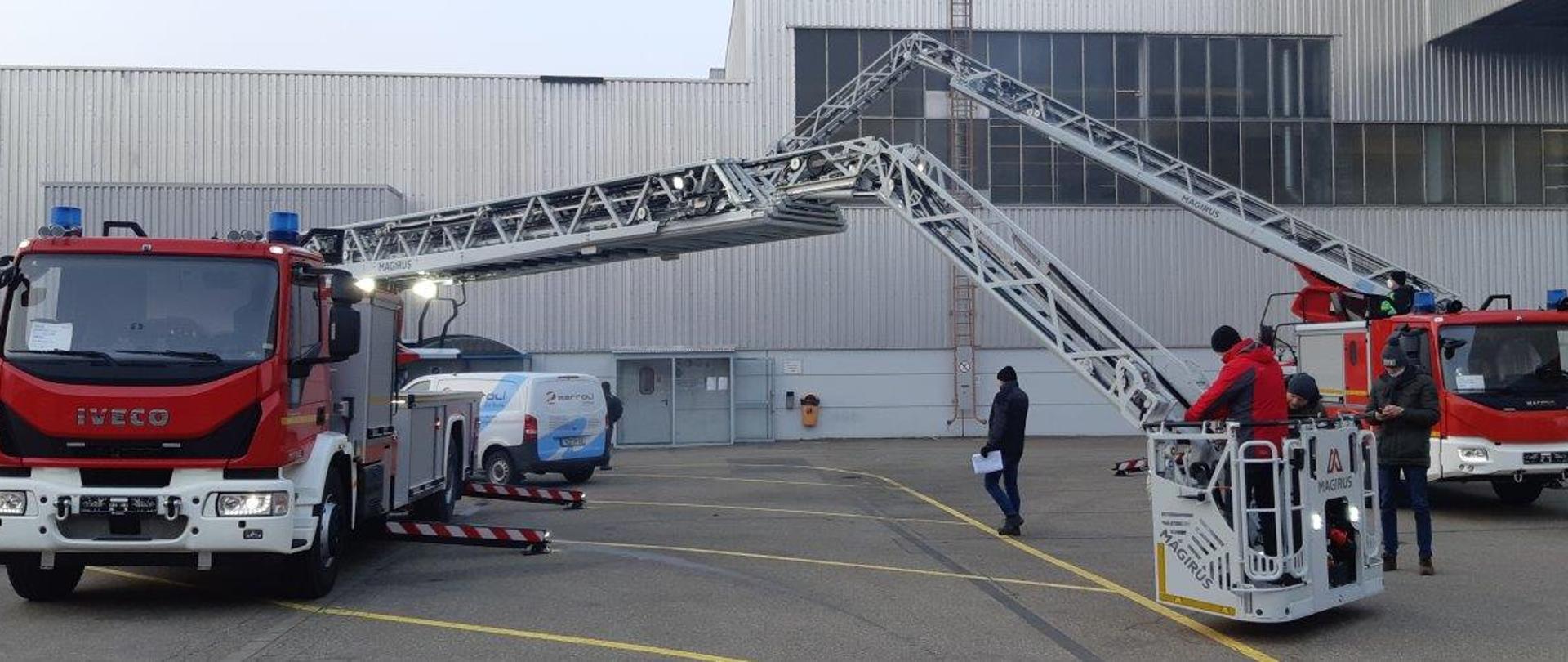 Zdjęcie przedstawia rozstawione dwie drabiny mechaniczne firmy Magirus