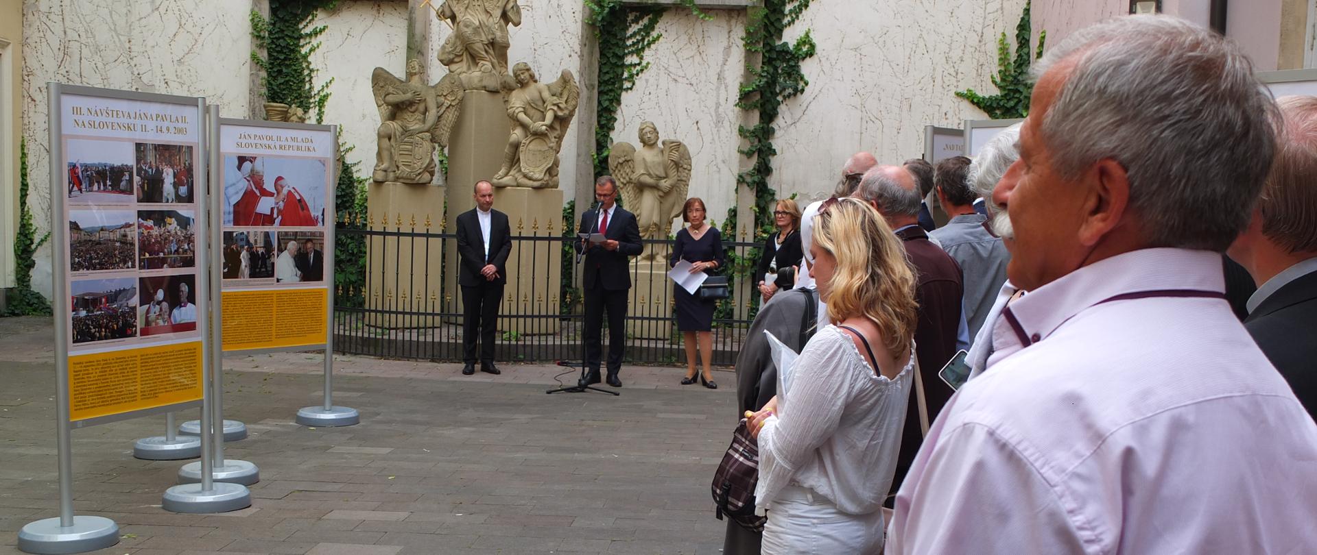 Zdjęcie przedstawia uczestników otwarcia wystawy Jan Paweł II i Słowacja na placu św. Jana Nepomucena w Bratysławie