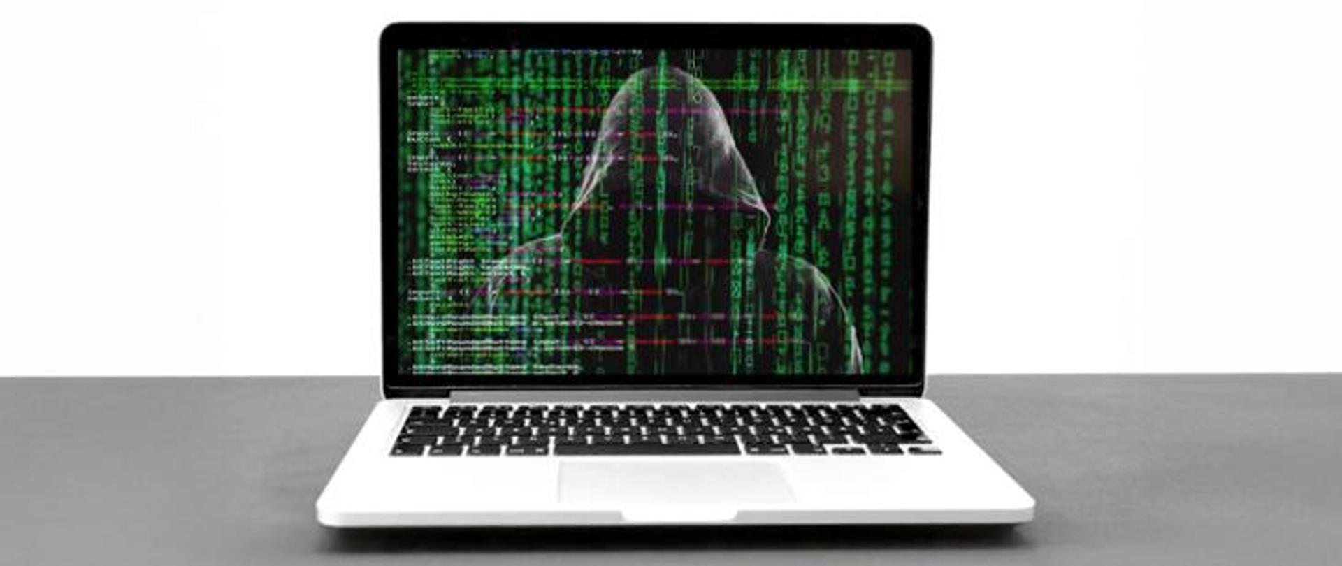 Zakapturzona osoba na ekranie komputera. 