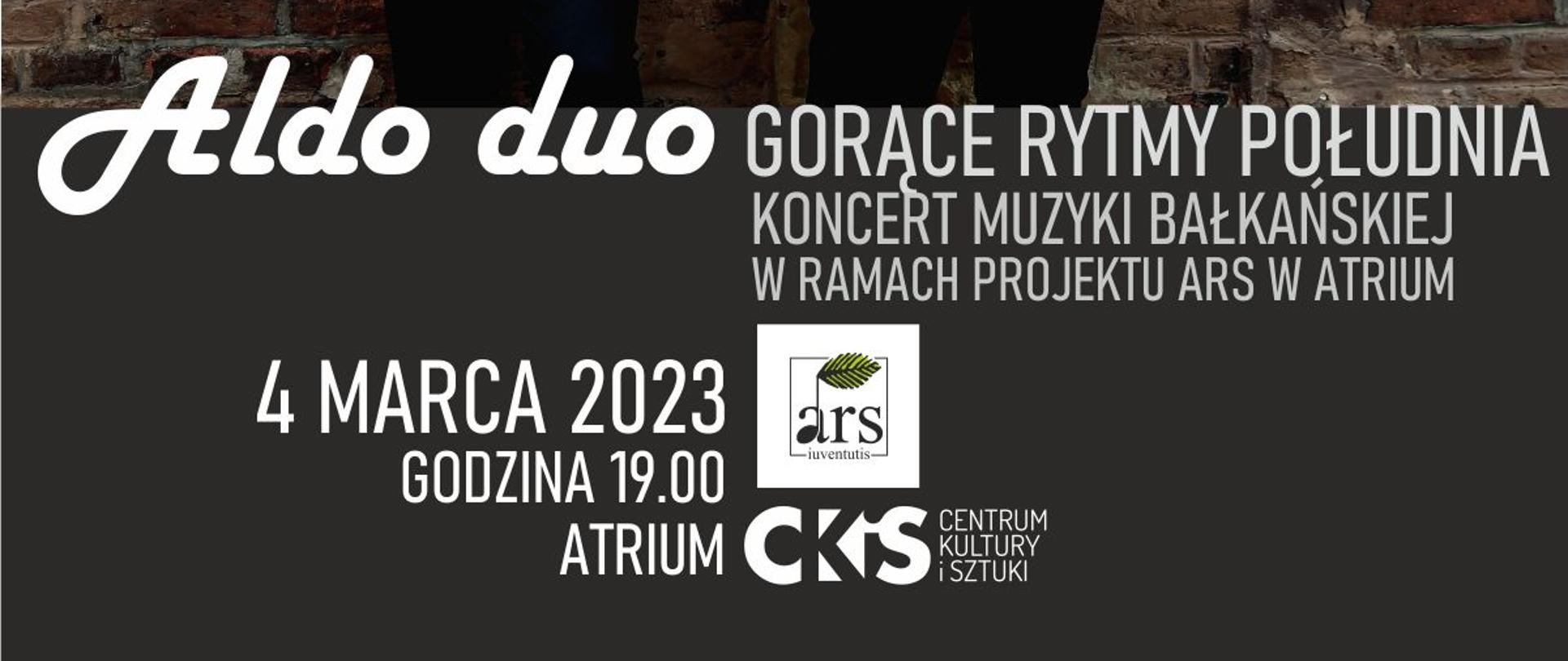 Plakat przedstawiający dwóch młodych ludzi, klarnecistę i akordeonistę stojących na tle muru z czerwonej cegły. Napis na plakacie białą czcionką. Nazwa zespołu Aldo Duo gorące rytmy południa koncert muzyki bałkańskiej w ramach projektu ARS w atrium 4 marca 2023 godzina 19:00 atrium centrum kultury i Sztuki na plakacie znajdują się dwa loga centrum kultury i Sztuki oraz Ars Juventus. 