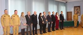 11 osób stojących w rzędzie na uroczystości wręczenia promes. 3 funkcjonariuszy oraz 8 osób cywilnych