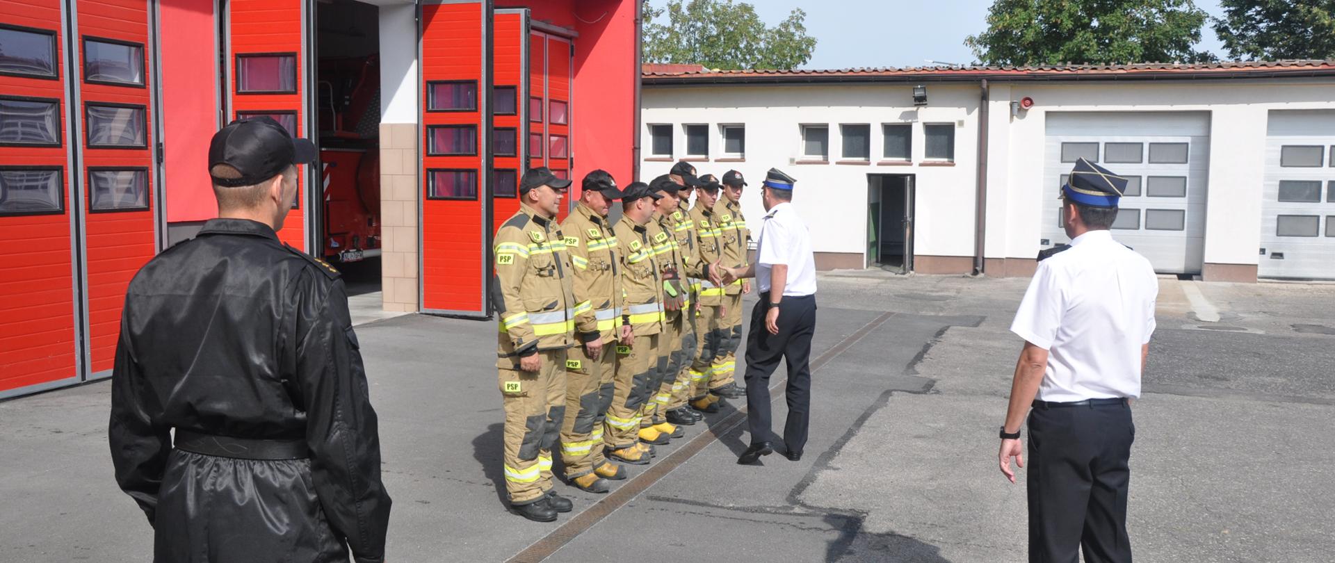 Zdjęcie przedstawia Z-ce Komendanta Wojewódzkiego PSP w Olsztynie st.bryg. Tomasza Ostrowskiego, który wita się ze zmianą służbową