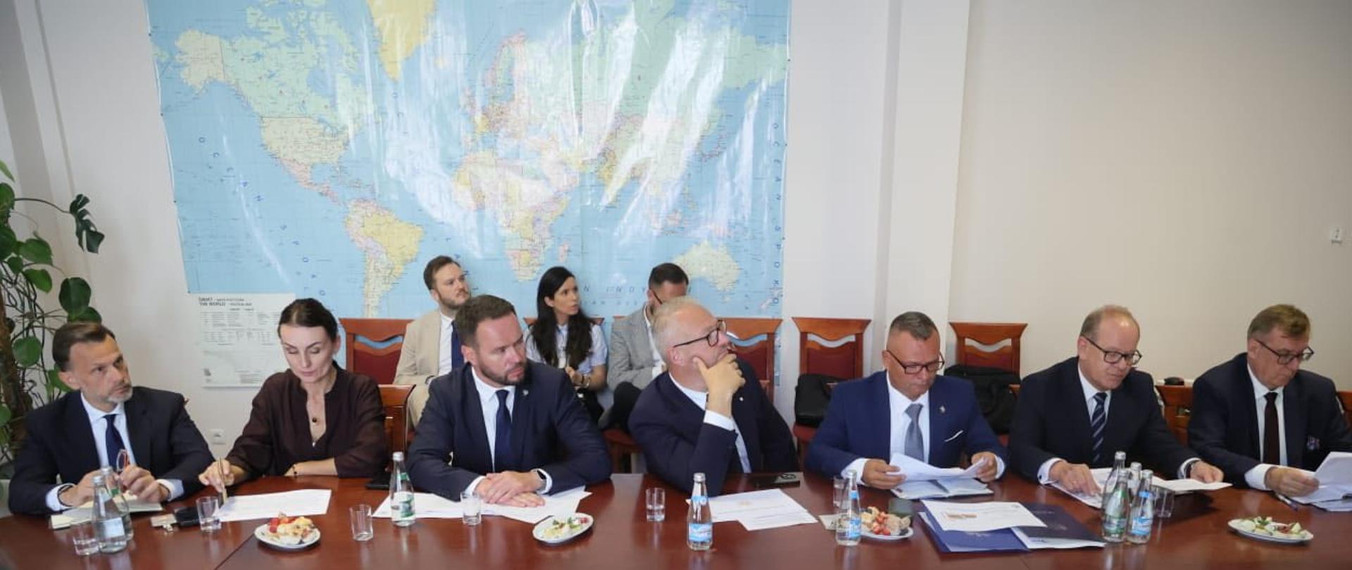 Mężczyźni siedzą przy stole 