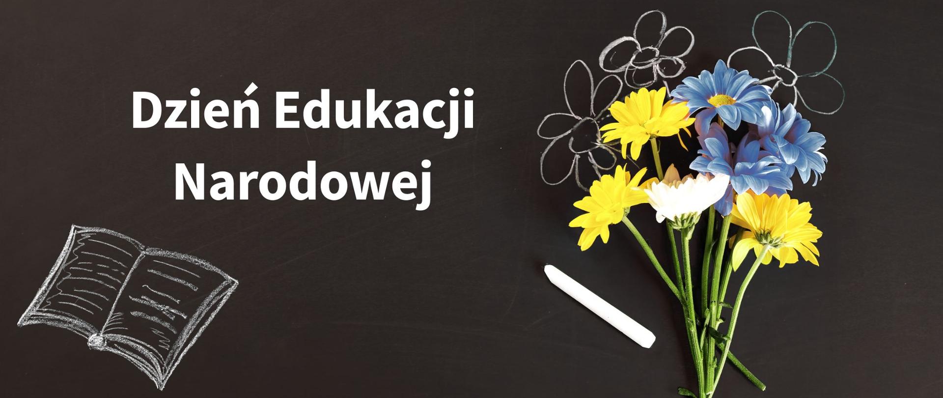 Na szkolnej, czarnej tablicy napis ,,Dzień Edukacji Narodowej", na prawo od napisu kreda szkolna, bukiet żywych kwiatów i kilka kwiatów dorysowanych kredą.