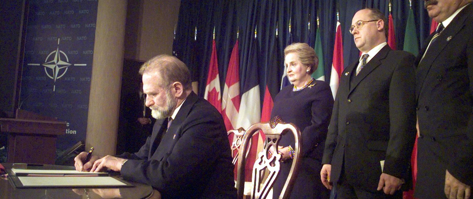 Polska, Czechy i Wêgry zosta³y w pi¹tek, 12 bm. oficjalnie przyjête w poczet cz³onków NATO. Podczas uroczystoci w Independence (Missouri, USA), sekretarz stanu USA Madeleine Albright przyjê³a dokumenty akcesyjne z r¹k szefów dyplomacji nowych pañstw cz³onkowskich -
Bronis³awa Geremka, Jana Kavana (Czechy) i Janosa Martonyiego (Wêgry). Na zdjêciu: szef polskiej dyplomacji Bronis³aw Geremek (przy stole) podpisuje w Bibliotece Trumana w Independence dokumenty akcesyjne cz³onkostwa Polski w NATO. Za nim od lewej stoj¹: amerykañska sekretarz stanu Madeleine Albright, czeski minister spraw zagranicznych Jan Kavan i wêgierski minister spraw zagranicznych Janos Martonyi. PAP/EPA
(CLIFF SCHIAPPA)