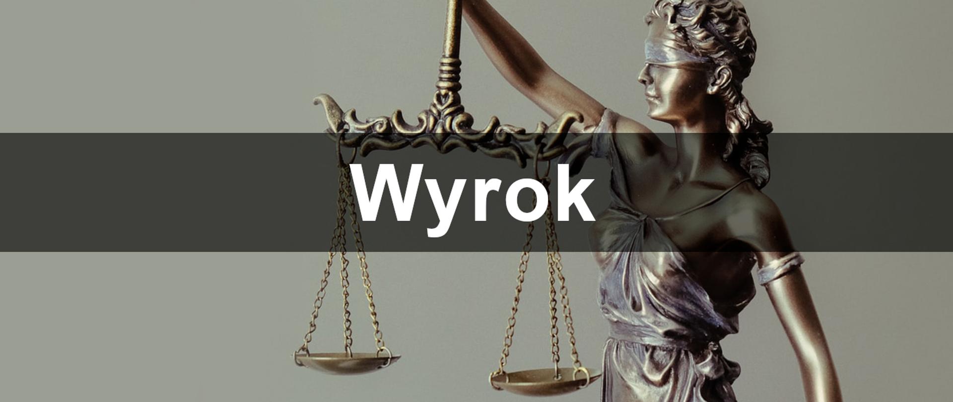 Baner z napisem wyrok z figurą temidy w tle