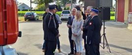 Delegacja z zaproszonych gości wręcza przekazanie pojazdu druhom OSP Zabawa, po lewej stronie znajduje się przód przekazywanego samochodu po prawej stronie strażnica 