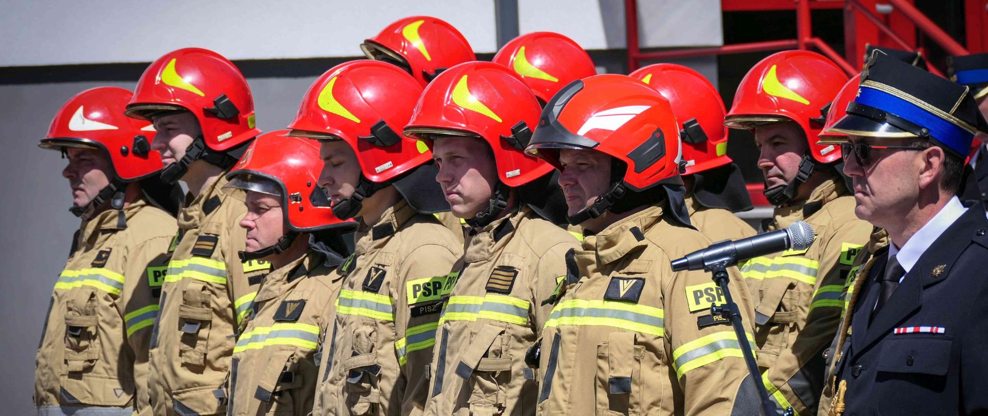 Strażacy stojący na placu
