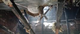 Zdjęcie przedstawia straty po pożarze. Nadpalona konstrukcja dachowa