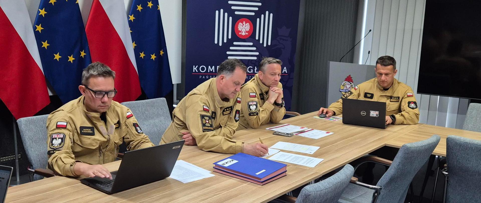Mężczyźni siedzący przy prezydialnym stole.