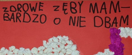 Na czerwonym tle widoczny napis "ZDROWY ZĘBY MAM - BARDZO O NIE DBAM". Jest on napisany pismem drukowanym, dziecięcym.