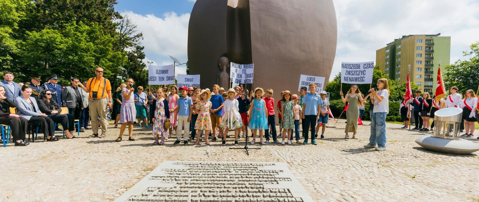 Dzieci stojące przy pomniku 