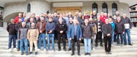 W centralnej części zdjęcia grupa ludzi na tle budynku kościoła.