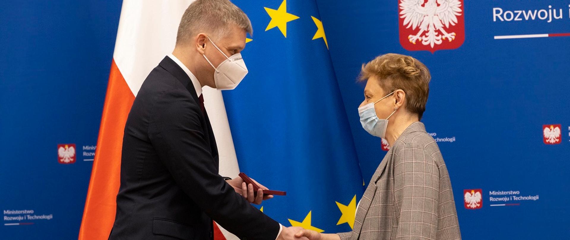 Minister rozwoju i technologii Piotr Nowak ściska dłoń Małgorzacie Getlich, zastępcy dyrektora Departamentu Architektury, Budownictwa i Geodezji