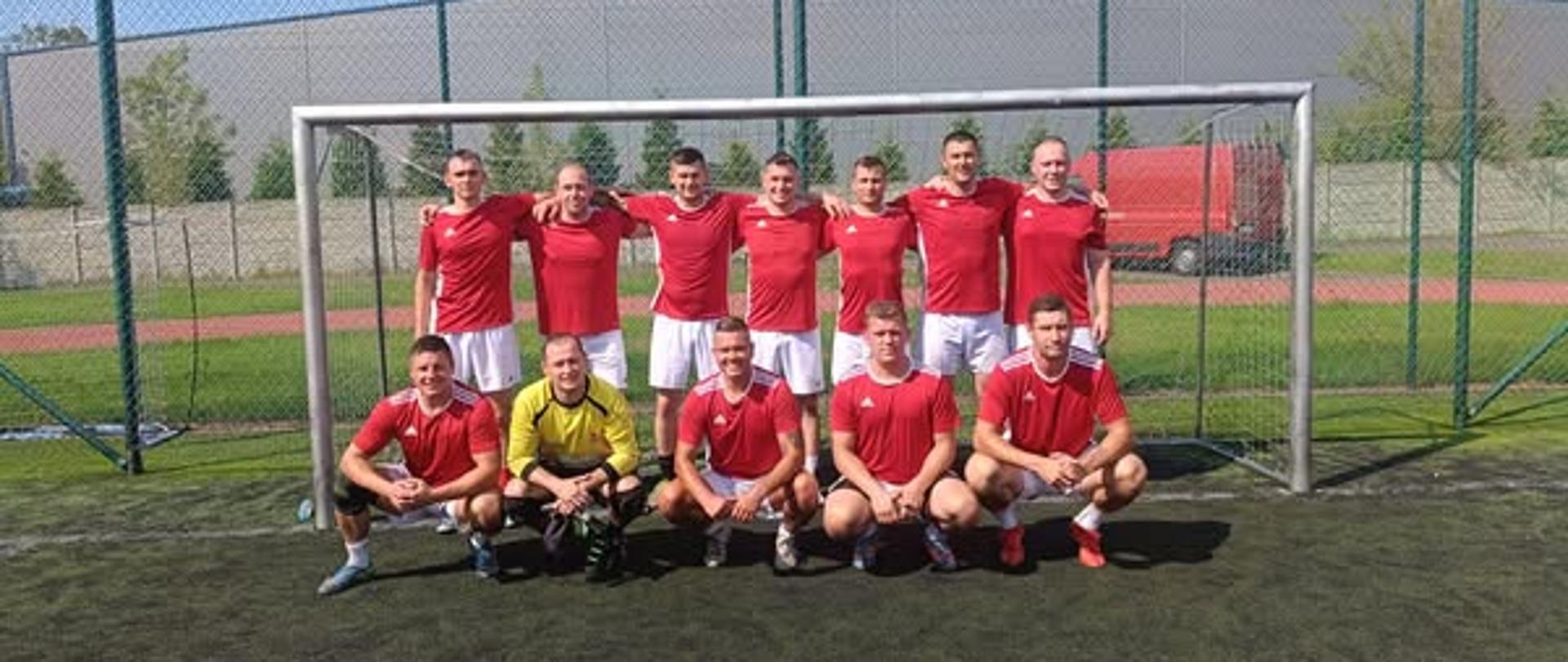 Wspólne zdjęcie zawodników - funkcjonariuszy, którzy brali udział w zawodach. Zdjęcie wykonane na boisku.