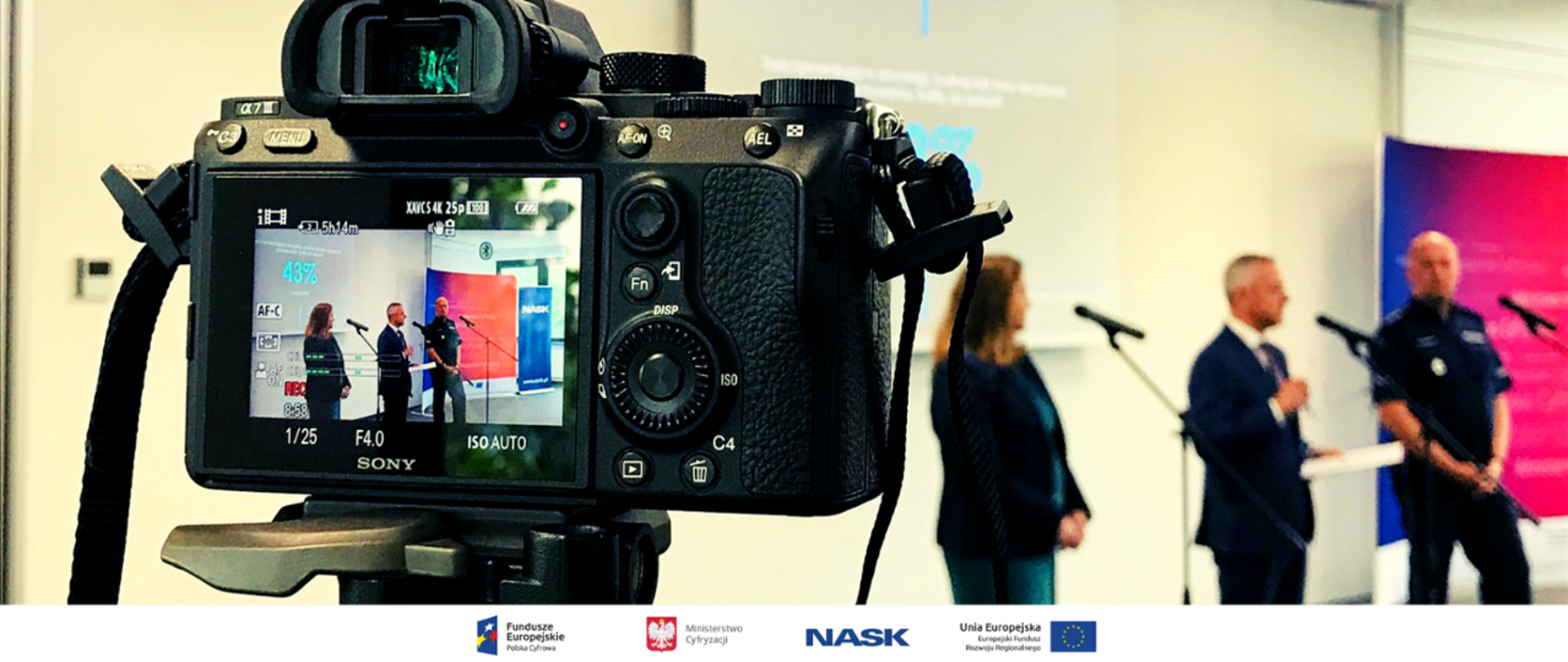 Zdjęcie przedstawiające aparat fotograficzny, w obiektywie Minister Marek Zagórski