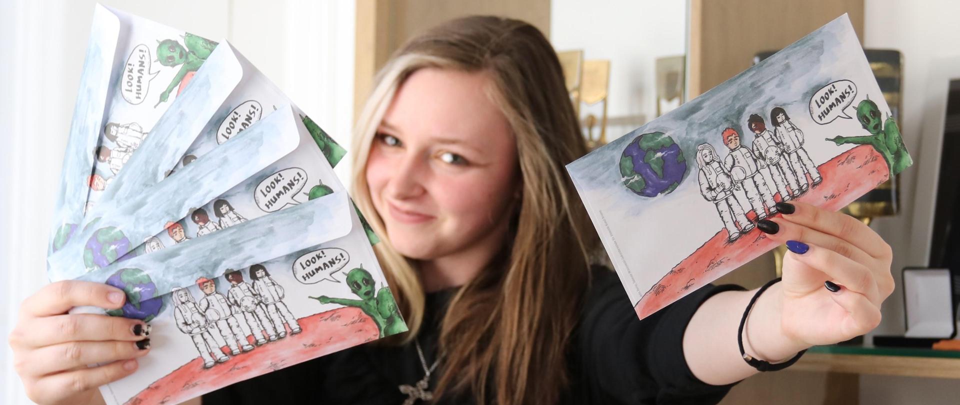 Uczennica Julia Durał prezentuje nagrodzone koperty