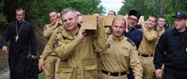 31. Piesza Pielgrzymka Wojska i Służb Mundurowych na Św. Górę Grabarkę - szef podlaskich strażaków niesie krzyż wotywny, za nim funkcjonariusze PSP z regionu