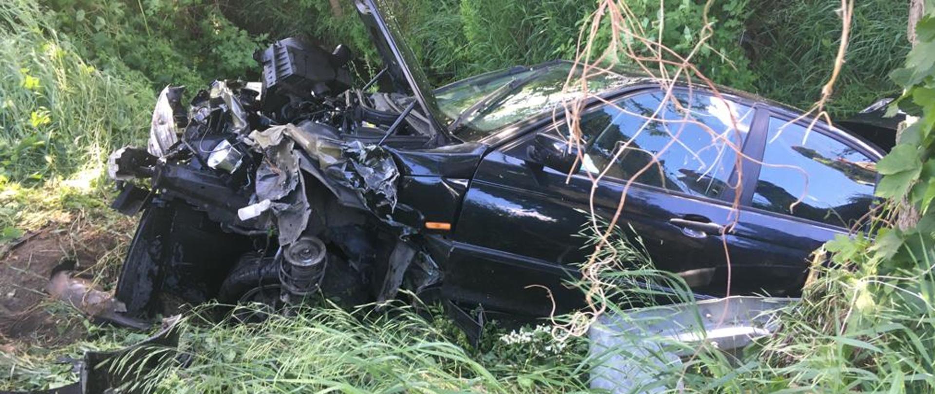 Na zdjęciu rozbity czarny samochód osobowy w rowie