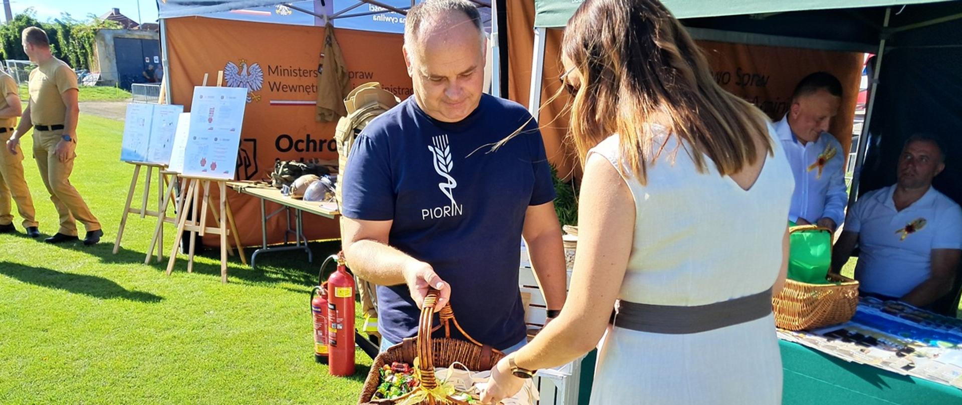 Inspektor WIORiN rozdaje gadżety inspekcyjne uczestnikom Dożynek 
